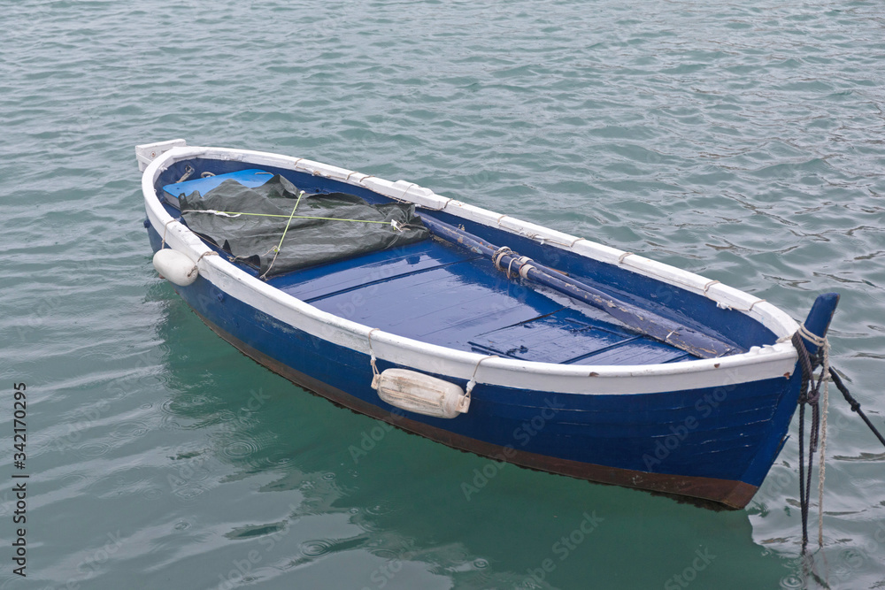 Naklejka premium Blue Boat at Sea