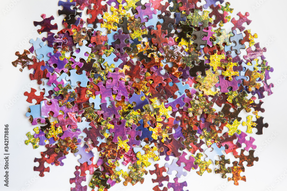 Abstract and colourful puzzle pieces scattered on a table Abstract and colourful puzzle pieces scattered on a table