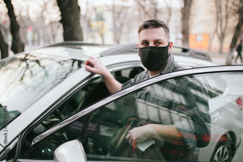 Young man driver in car vehicle wearing medicine mask