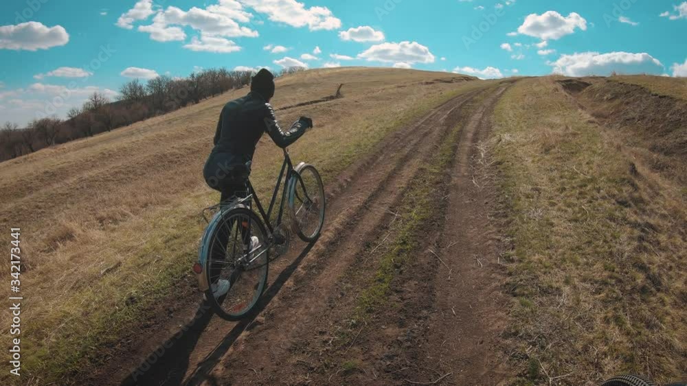 Woman cyclist riding mountain bike. Cycling along the forest road on sunny day. Adventure Lifestyle Concept. Woman cyclist riding mountain bike. Cycling along the forest road on sunny day. Adventure Lifestyle Concept.