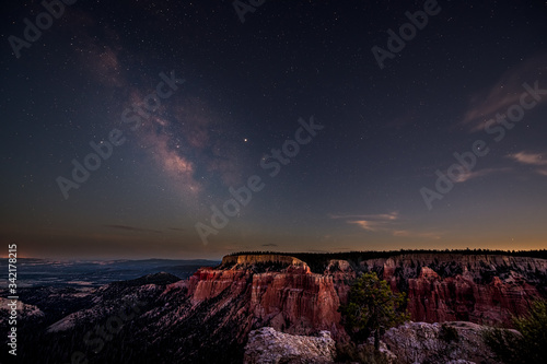 Night sky with dark milky way starscape in Bryce Canyon National Park in Utah at Pariah view overlook and rock formations panoramic viewpoint photo