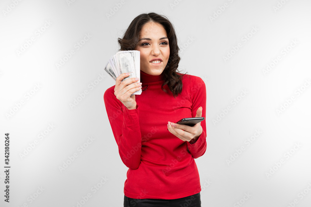 brunette holds her salary in her hands on a white background with copy space brunette holds her salary in her hands on a white background with copy space