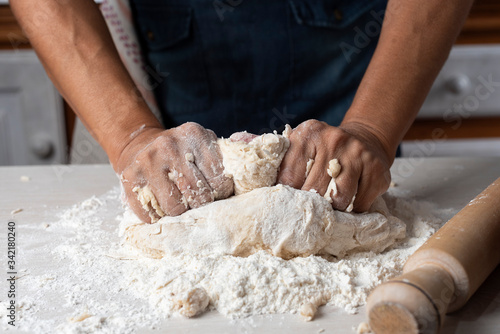 hands kneading flour, yeast eggs bakery ingredients milk honey in home kitchen © Alejandro Piorun