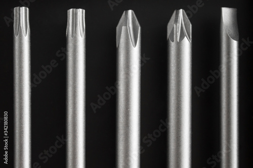 A set of long bits for a screwdriver. Different form  five kinds. Dark background.