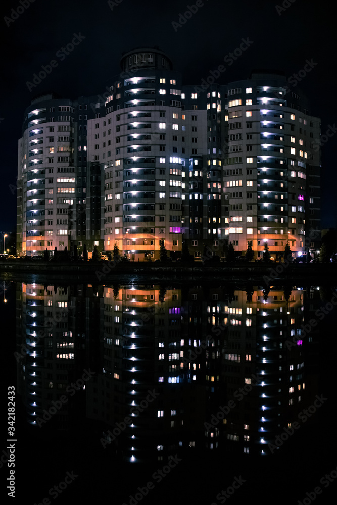 apartment building by the river in a night city