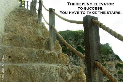 Inspirational motivational quote - There is no elevator to success. You have to take the stairs. On background of wooden fence on the cliff. photo