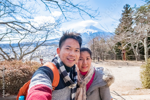A couple takes a photo with mountain Fuji as background