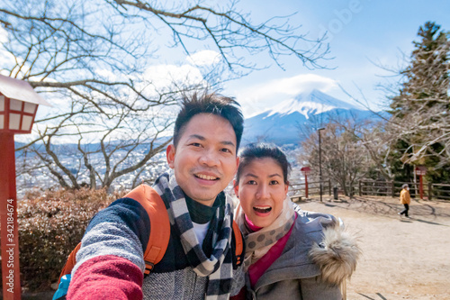A couple takes a photo with mountain Fuji as background