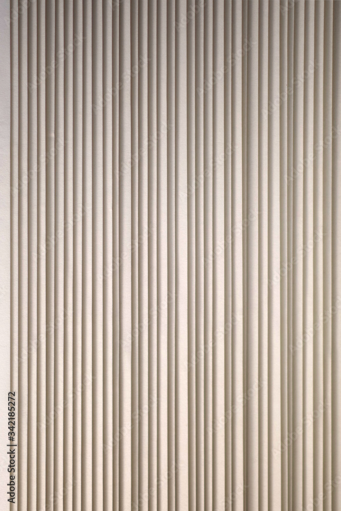 Sectional full frame close-up view of light colored textured tall vertical window blinds Sectional full frame close-up view of light colored textured tall vertical window blinds