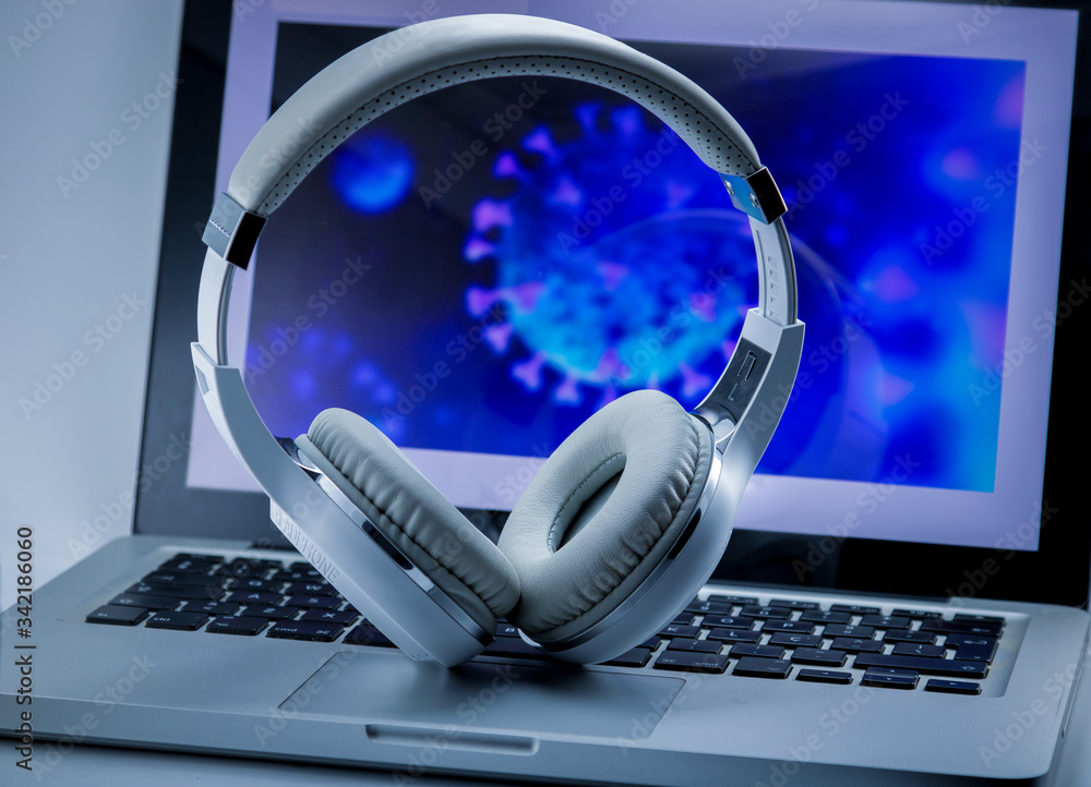 White design headphones with computer illustrating the Covid-19 virus. Work  at home. Stock Photo | Adobe Stock