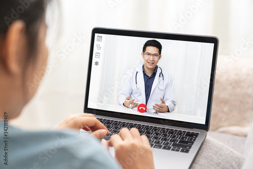 Fényképezés Asian chinese doctor video conference call online talking for follow up remotely with medical coronavirus result at home