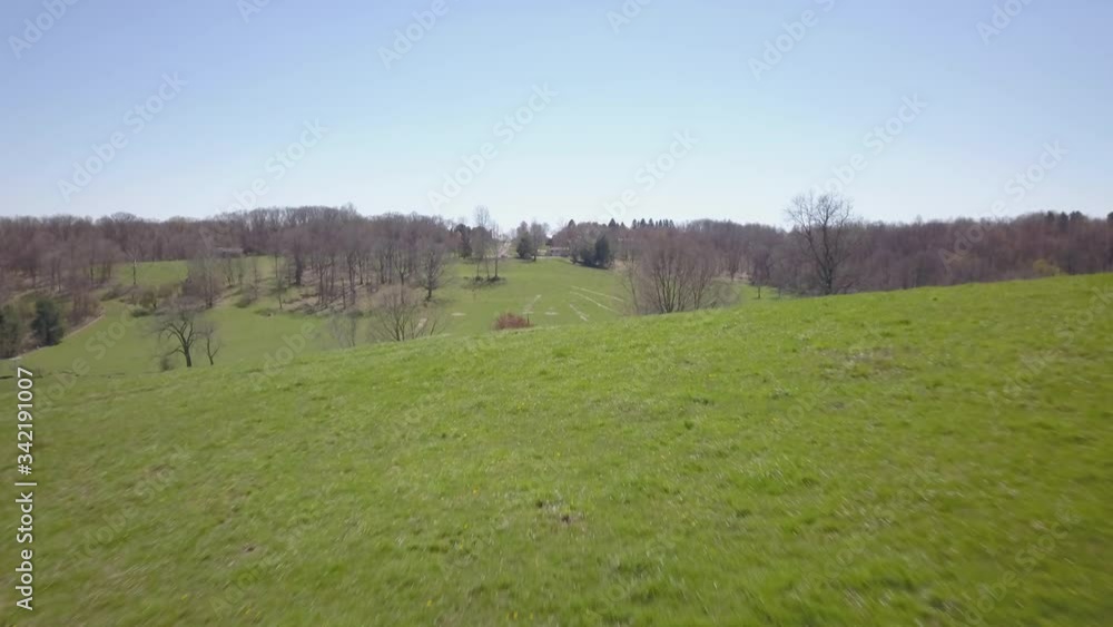 Drone reveals farm over rolling green hills Drone reveals farm over rolling green hills