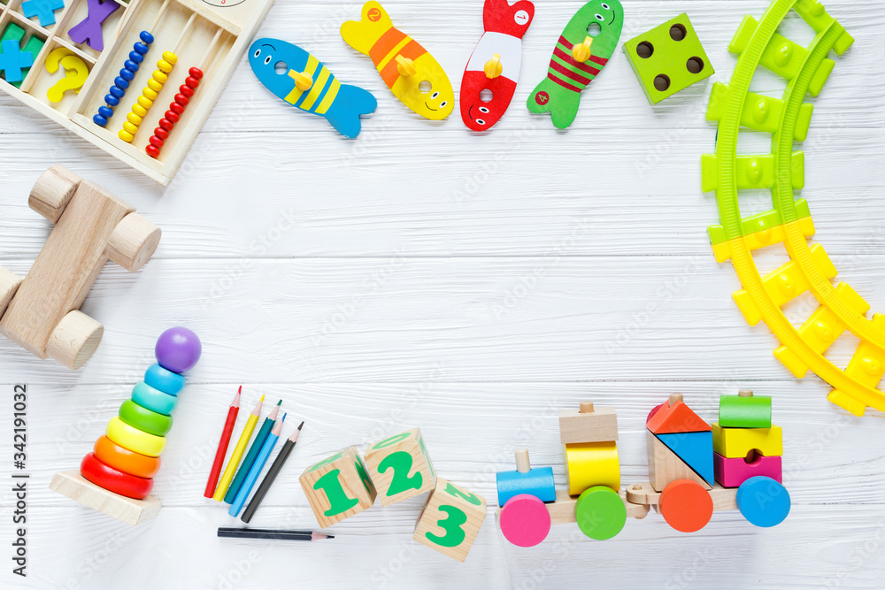 Kids toys: pyramid, wooden blocks, xylophone, train on white wooden background. Top view. Flat lay. Copy space for text
Kids toys: pyramid, wooden blocks, xylophone, train on white wooden background. Top view. Flat lay. Copy space for text