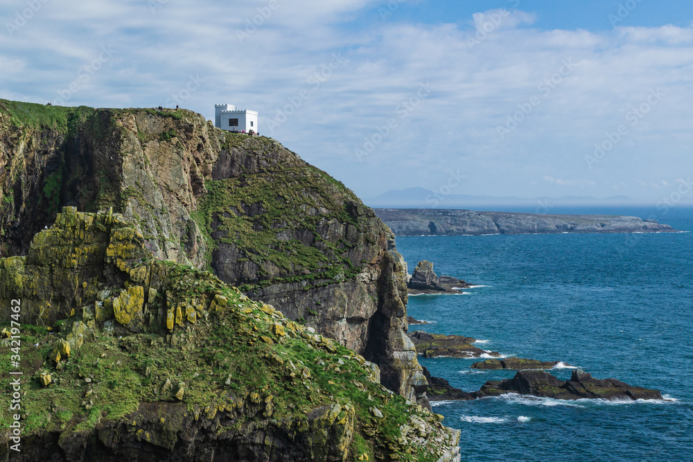 Dramatic scenery of the coast consisting of cliffs and a white house