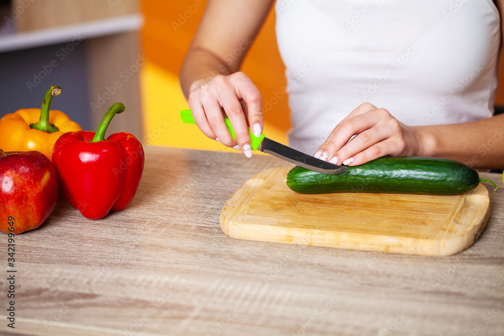 Closeup of woman slices cucumber for fresh salad Closeup of woman slices cucumber for fresh salad