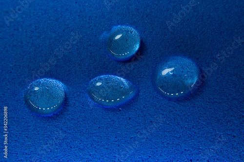 Gotas de álcool em gel com brilhos de luz em fundo azul com textura