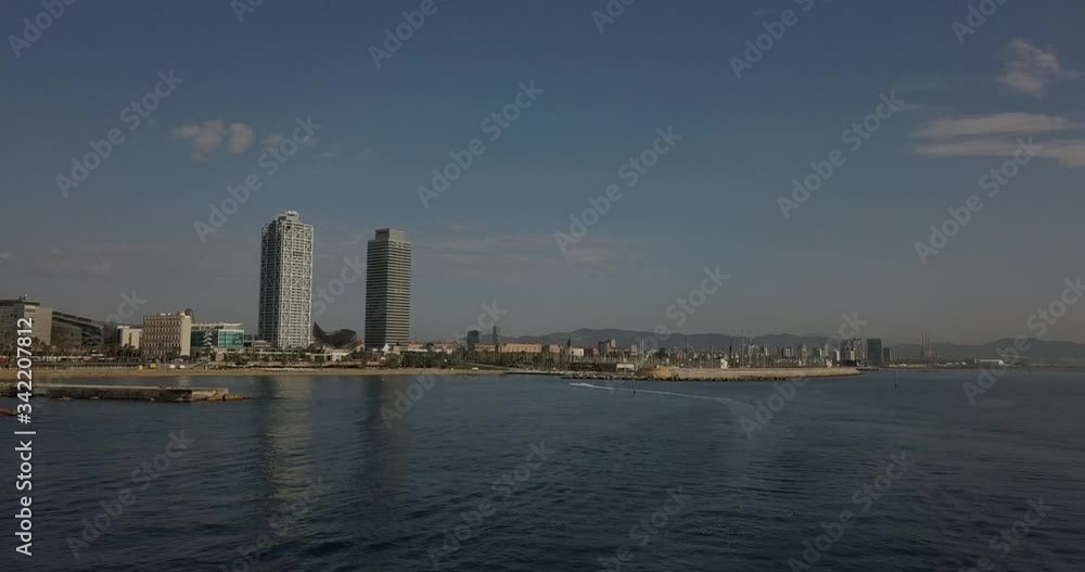 Aerial Dolly forward jet ski entering Port Olimpic Mapfre tower in distance Aerial Dolly forward jet ski entering Port Olimpic Mapfre tower in distance