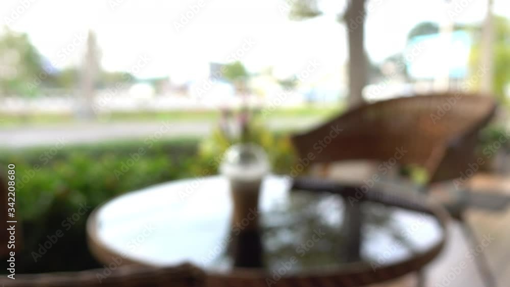 blur scene outdoor cafe with coffe cup put on table outside garden view in the morning blur scene outdoor cafe with coffe cup put on table outside garden view in the morning