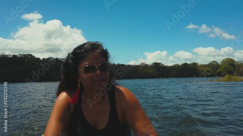 A woman sitting in a dug canoe on her way to visit the the Embera tribal community in the rainforest of Panama, photo