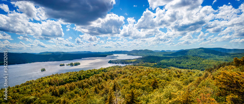 Fulton Chain Lakes view from the Adirondack Mountains in Upstate New York. Taken from the mountain summit after a short hiking trail. Lots of trees and clouds over the water. Camping in the Catskills