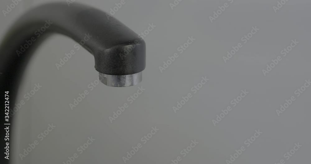 Closeup of a dripping faucet on a white background Closeup of a dripping faucet on a white background