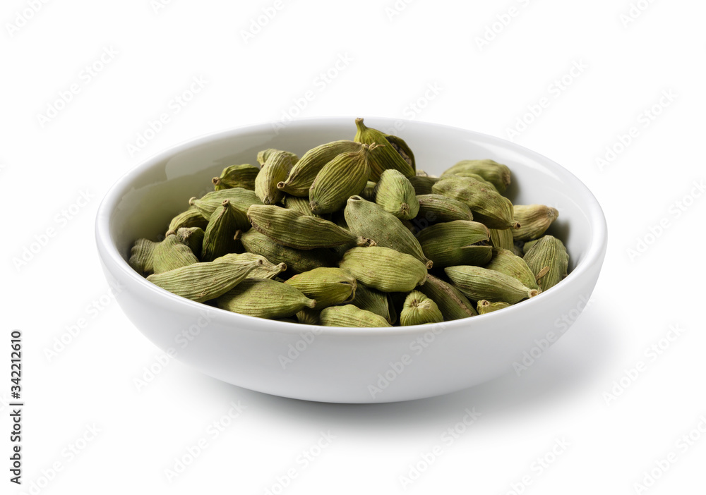 Cardamom seeds in a plate placed on a white background Cardamom seeds in a plate placed on a white background