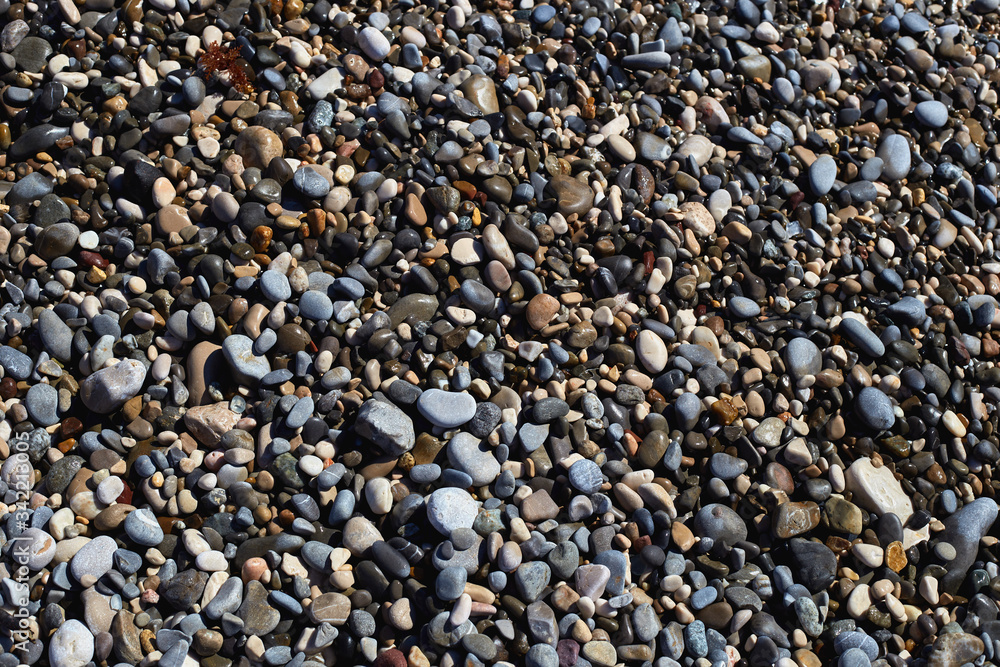 Closeup of small stones. Round stones. The sea shore is covered with grey stones. Closeup of small stones. Round stones. The sea shore is covered with grey stones.