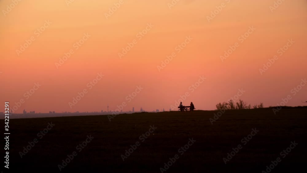 People are talking while sunset on a bank with the skyline of cologne in the background. People are talking while sunset on a bank with the skyline of cologne in the background.