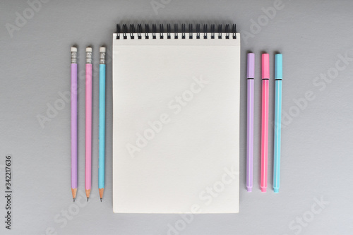 Libreta y colores sobre fondo color gris
