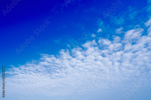 Bright blue sky There are small  white clouds spread beautifully. The perfect sky is used as a background in natural scenery.