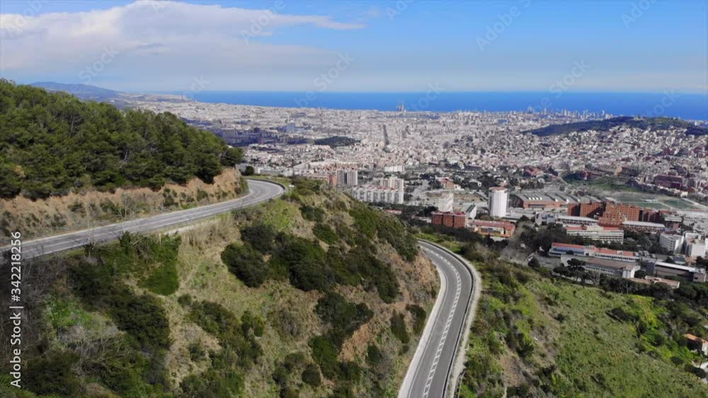 Aerial view of Spain highway, fly up to reveal Badalona, coast in Catalonia, Spain with Mediterranean Sea in the distance, car travel around the freeway in Barcelona Aerial view of Spain highway, fly up to reveal Badalona, coast in Catalonia, Spain with Mediterranean Sea in the distance, car travel around the freeway in Barcelona