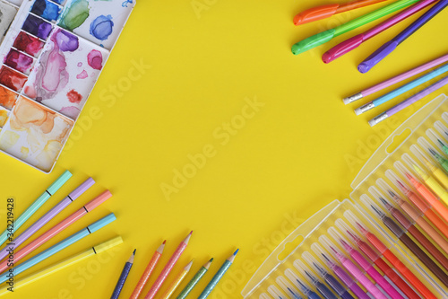 Colores y marcadores de colores sobre fondo amarillo