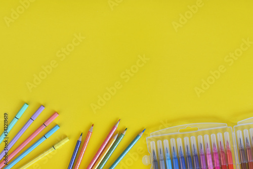 Colores y marcadores de colores sobre fondo amarillo