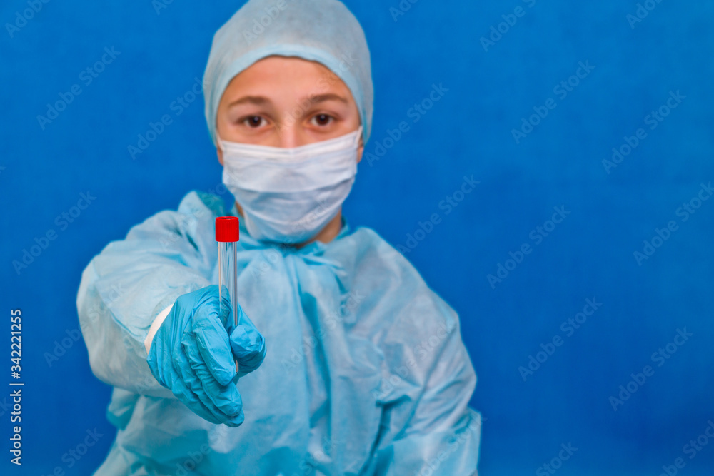 Female medical worker holding test tube on a blue background. Coronavirus test. Female medical worker holding test tube on a blue background. Coronavirus test.