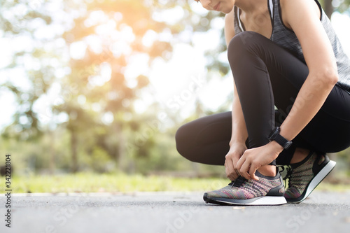 Young woman tying jogging shoes. photo