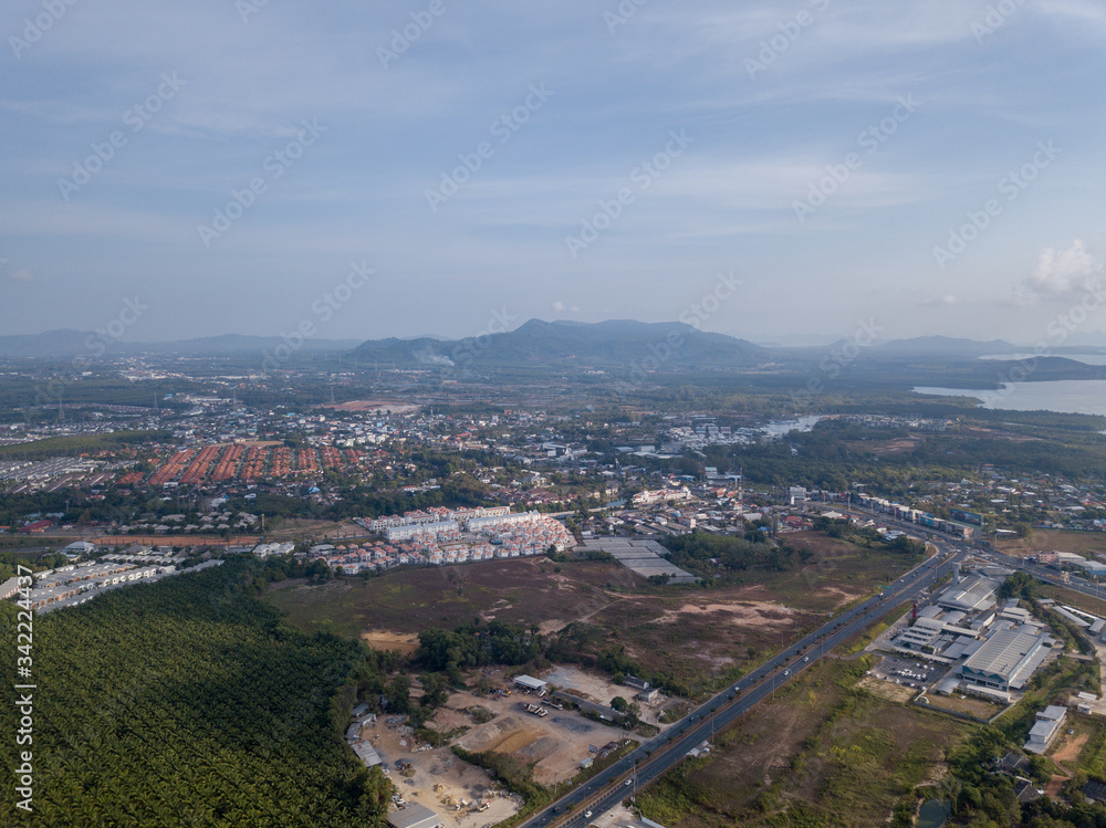 Fototapeta premium aerial view of the city around the picturesque mountains at sunrise, Kathu, Phuket
