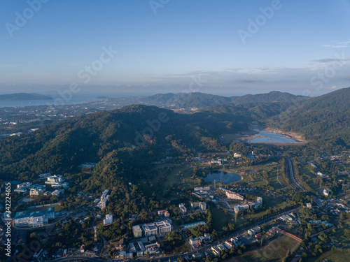 Beautiful lake located on a golf course surrounded by houses and mountains at dawn, photo from a drone. In the lake the reflection of the sky. Great background for travel and golf advertising. © Dima
