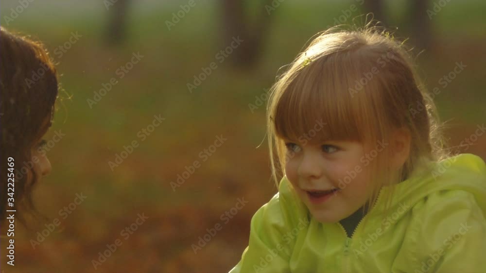 Sequence of slow motion shots of the happy mum and little girl play with autumn foliage Sequence of slow motion shots of the happy mum and little girl play with autumn foliage