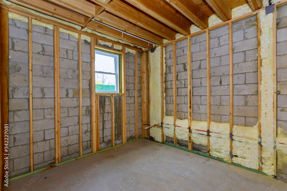 House in unfinished under construction insulation foam the wall of a basement House in unfinished under construction insulation foam the wall of a basement