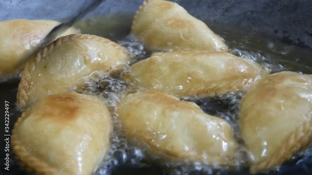 Curry puffs of local called Karipap fried using hot cooking oil inside a pan. It is one of the traditional cakes in Malaysia. Skin made from wheat flour mixture and the inside is potato and curry. Curry puffs of local called Karipap fried using hot cooking oil inside a pan. It is one of the traditional cakes in Malaysia. Skin made from wheat flour mixture and the inside is potato and curry.