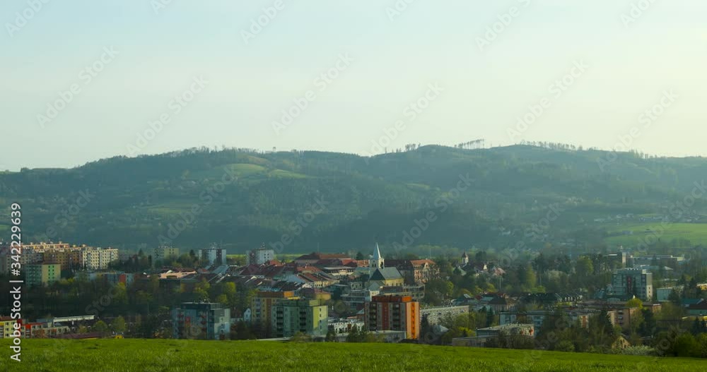 View of the town of Valasske Mezirici in a valley surrounded by mountains in a protected area of Beskydy and hills during a sunny day, you can see the city center captured from the hill in 4k 60fps View of the town of Valasske Mezirici in a valley surrounded by mountains in a protected area of Beskydy and hills during a sunny day, you can see the city center captured from the hill in 4k 60fps