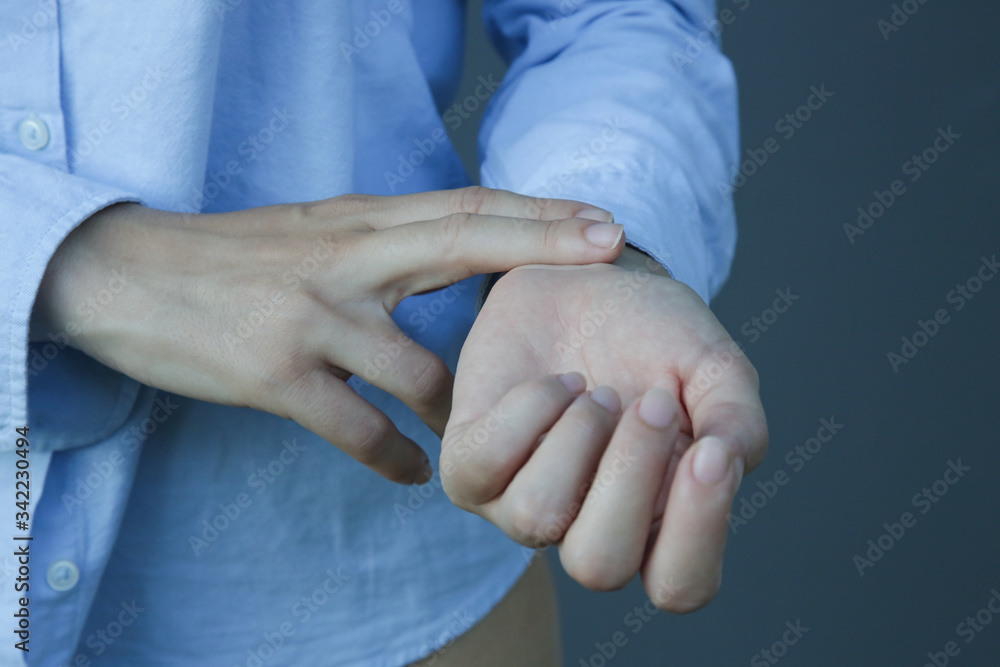 Woman checking pulse by putting 2 fingers on the inside of her wrist. Woman checking pulse by putting 2 fingers on the inside of her wrist.