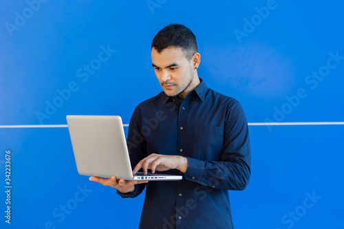 young asian business man, Happy young man working on laptop,at his working from home,Mock up copy space,On a blue background