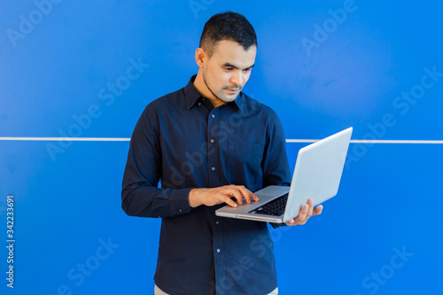 young asian business man, Happy young man working on laptop,at his working from home,Mock up copy space,On a blue background