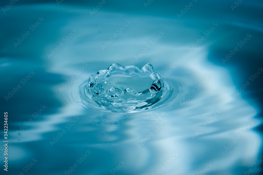 Water drops splash and circle reflextion background.Close up fresh water drops falling into the water and ripples of light blue. Water drops splash and circle reflextion background.Close up fresh water drops falling into the water and ripples of light blue.