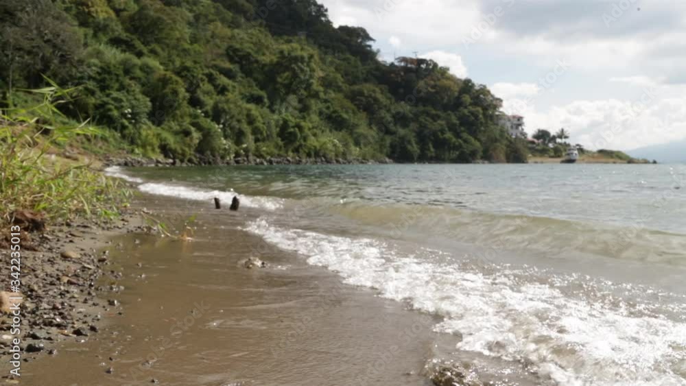 Lake Atitlan coast of Guatemala, between mountains and volcanoes - dark sand on the seashore, among trees Lake Atitlan coast of Guatemala, between mountains and volcanoes - dark sand on the seashore, among trees