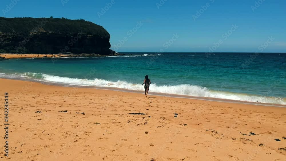 Beautiful Adult Woman Runs to the Water on an Australia Beach, Clear Sunny Day Beautiful Adult Woman Runs to the Water on an Australia Beach, Clear Sunny Day
