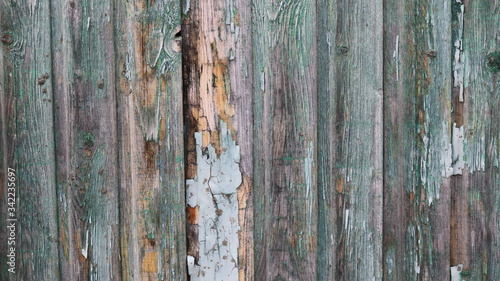 background of an old dilapidated fence with peeled green paint