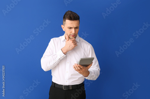 Young man with calculator o...