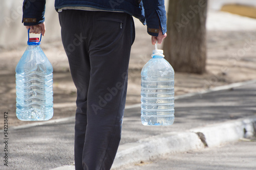 Canvastavla Mykolayiv, Ukraine - April 14, 2020: Man carrying bottled water